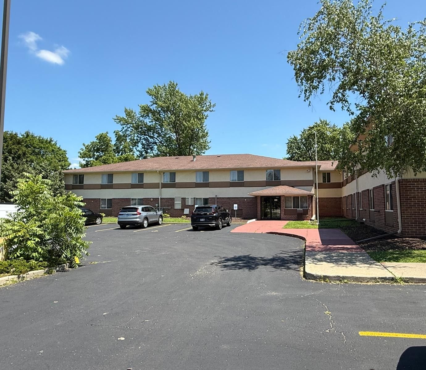 A two-story motel with a parking lot in front.