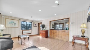 A spacious living area with a fireplace, a dining table, and a kitchen area visible through an open door. - City Centre Inn at Newport News (Newport News)