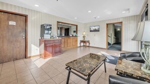 A hotel lobby with a reception desk, a marble coffee table, and leather seating. - City Centre Inn at Newport News (Newport News)