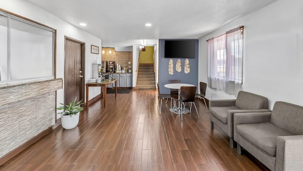 Una sala de estar moderna con un sofá, una mesa de comedor y una cocina al fondo.