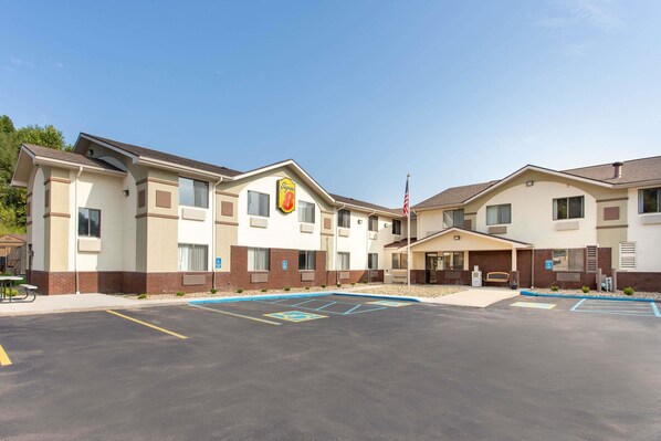 A hotel with a parking lot, a flag, and a sign indicating it is a Super 8 hotel.