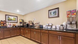 Een hotelkeuken met houten kastjes, een koffiehoek en een ontbijtbalk.
