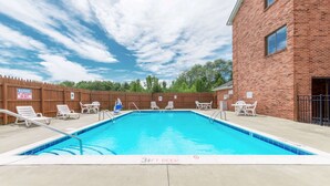 A rectangular swimming pool with a wooden fence and lounge chairs. - Super 8 by Wyndham Georgetown (Georgetown)