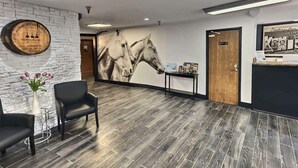 A reception area with a modern design, featuring a stone wall, a large horse mural, and a reception desk. - Super 8 by Wyndham Georgetown (Georgetown)