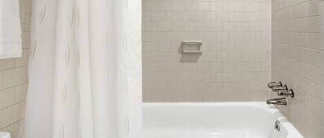 A modern bathroom with a bathtub, a showerhead, and a towel rack.