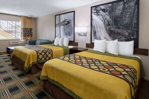 A hotel room with two beds, a sofa, and a large window with curtains.
