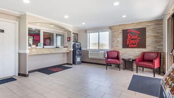 A Red Roof Inn reception area with a counter, ATM, and seating area.