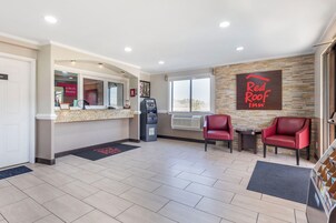 A Red Roof Inn reception area with a counter, ATM, and seating area.
