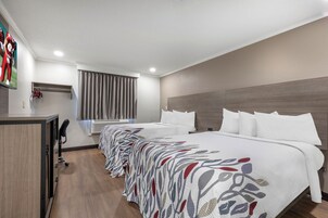 Una habitación de hotel con una cama grande, un escritorio y una silla.
