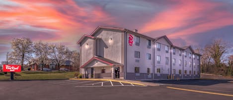 Un hotel Red Roof Inn con un estacionamiento al frente.
