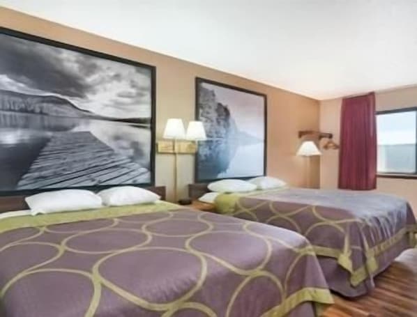 A hotel room with two beds, a large painting of a seascape, a window with a view, and a lamp on the nightstand.