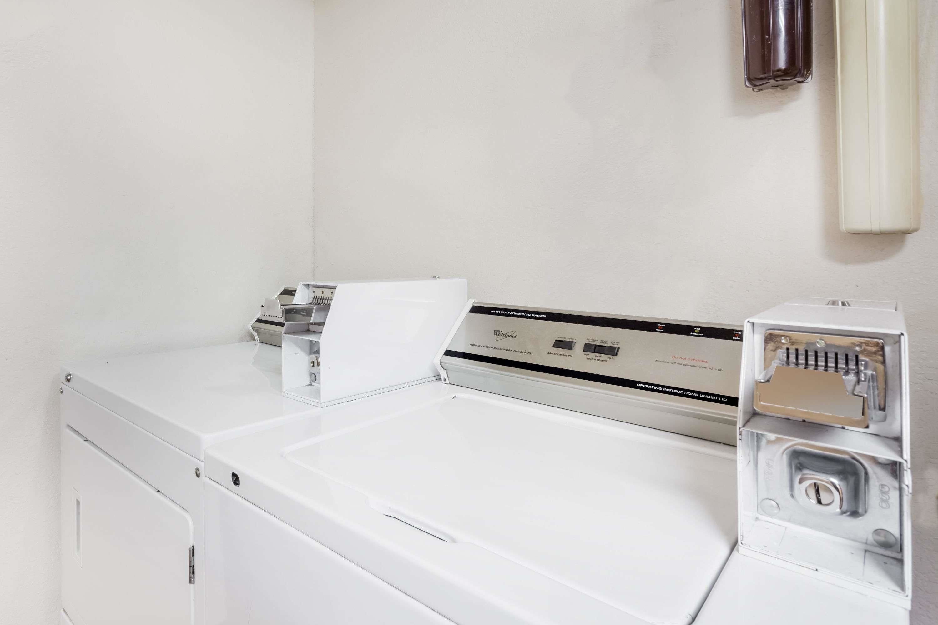 A white washing machine with a control panel and a detergent drawer.