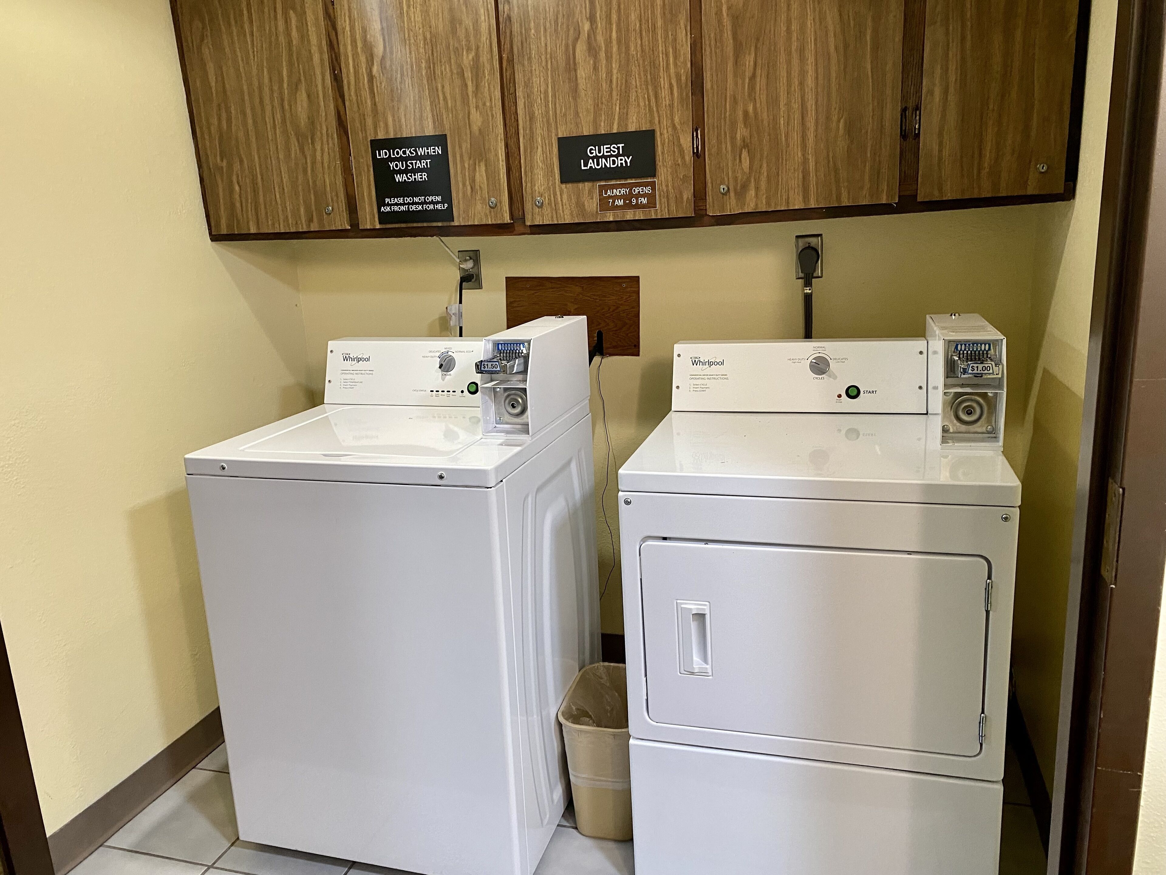 A laundry area with two Whirlpool washers and a guest laundry cabinet.