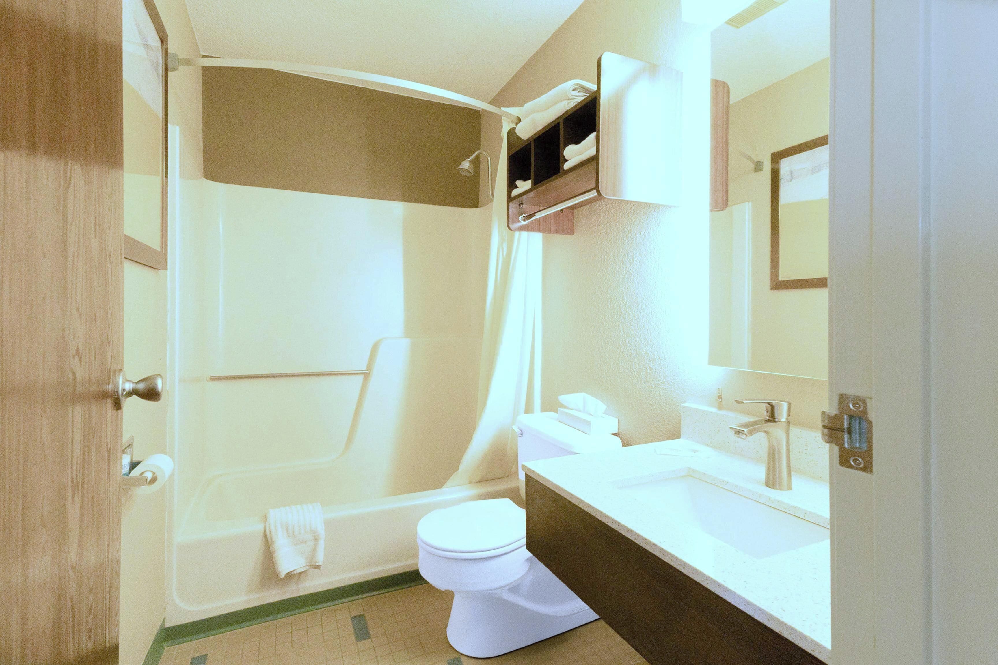 Une salle de bain équipée d’une douche, de toilettes, d’un lavabo et d’un miroir.