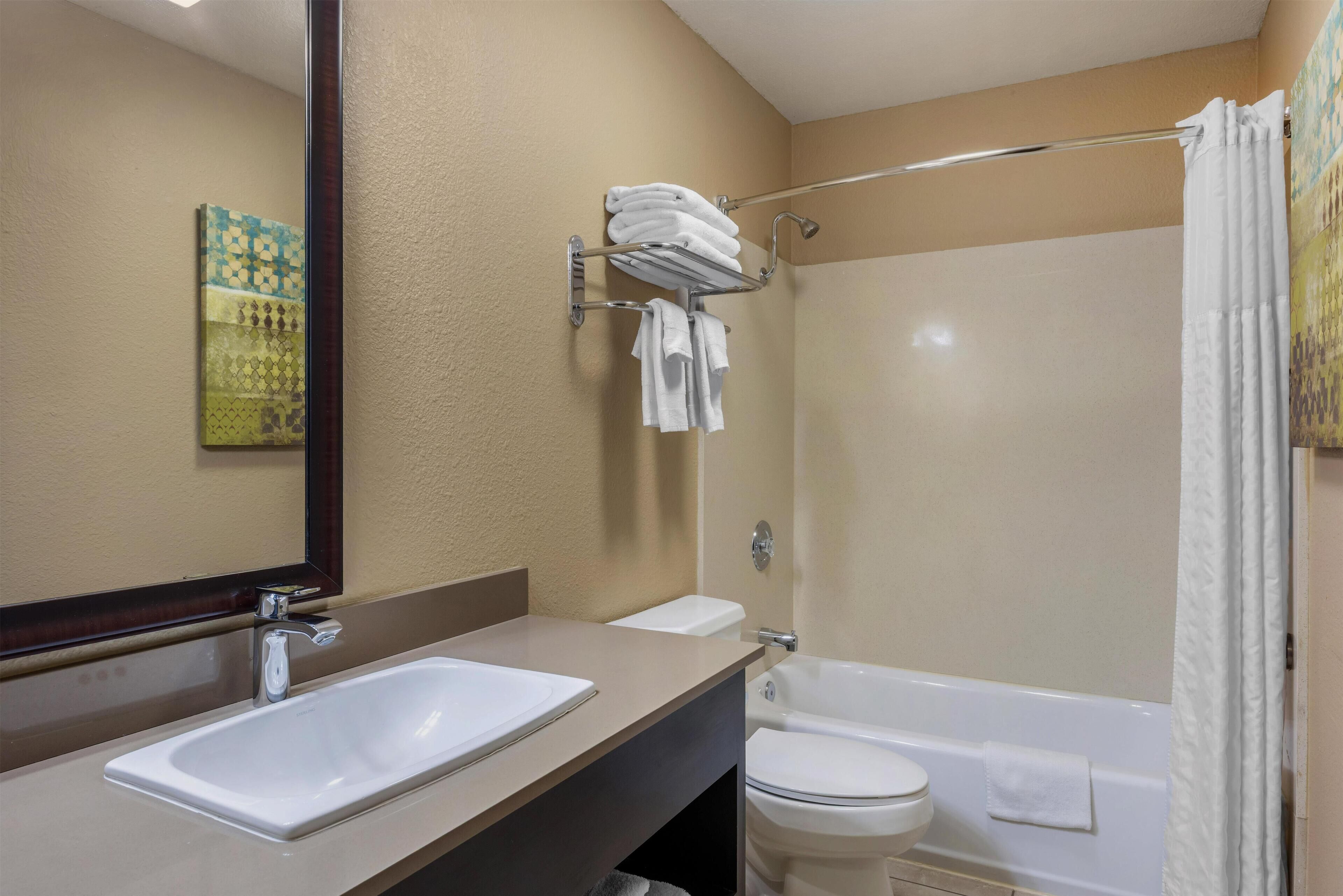 A bathroom with a double sink, a toilet, and a bathtub.