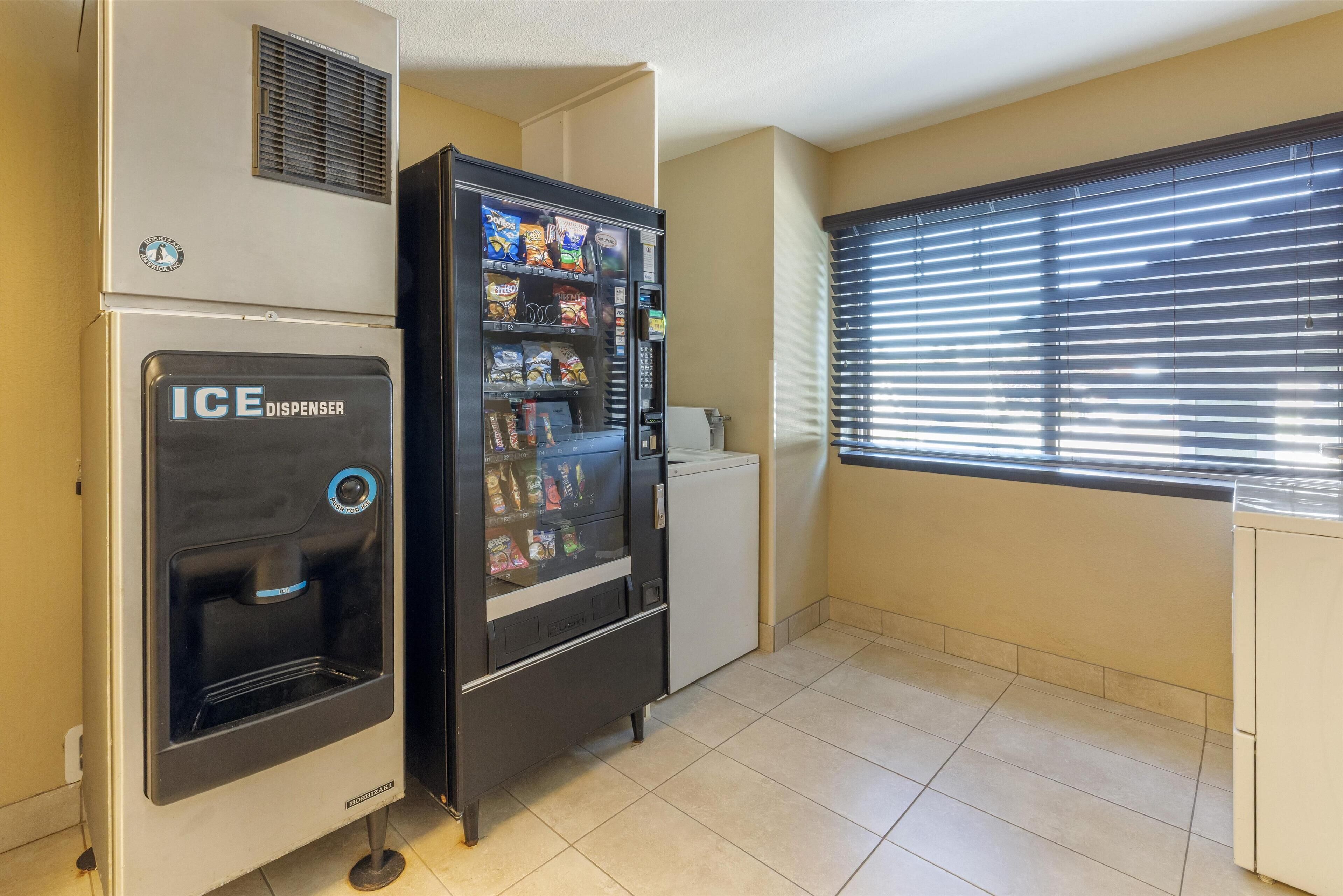 Una kitchenette con dispensador de hielo y máquina expendedora.