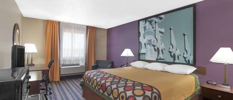 A hotel room with a large bed, two bedside tables with lamps, a desk with a chair, a large window with curtains, and a wall painting.