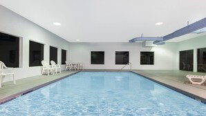 A swimming pool with clear water, surrounded by white walls and windows. - Super 8 by Wyndham Lacey Olympia Area (Lacey)