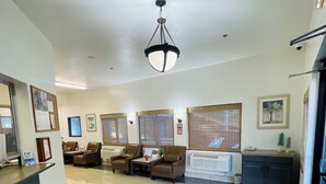 A spacious lobby with a reception desk, several seating areas, and a large chandelier. - Super 8 by Wyndham Lacey Olympia Area (Lacey)