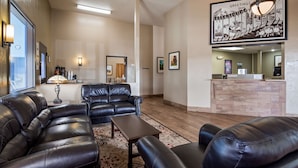 A hotel lobby with leather sofas, a reception desk, and framed artwork on the walls. - SureStay Hotel by Best Western Ellensburg (Ellensburg)