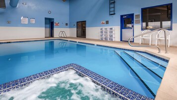 Una piscina techada, sillones reclinables de piscina