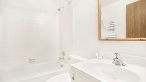 A bathroom with a white bathtub, a sink, and a toilet. - Super 8 by Wyndham Riverton (Riverton)