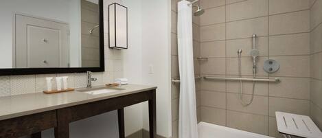 A modern bathroom with a shower, a sink, and a mirror.
