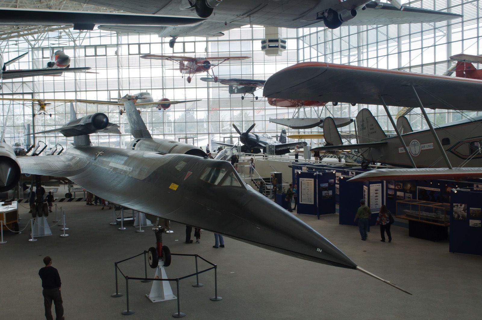 A museum with various aircraft on display, including a prominent silver fighter jet.