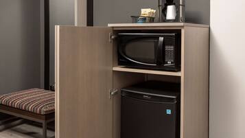 A compact kitchenette with a microwave, a coffee maker, and a small refrigerator.