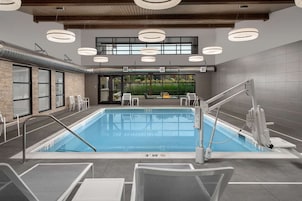 Una piscina techada, sillones reclinables de piscina