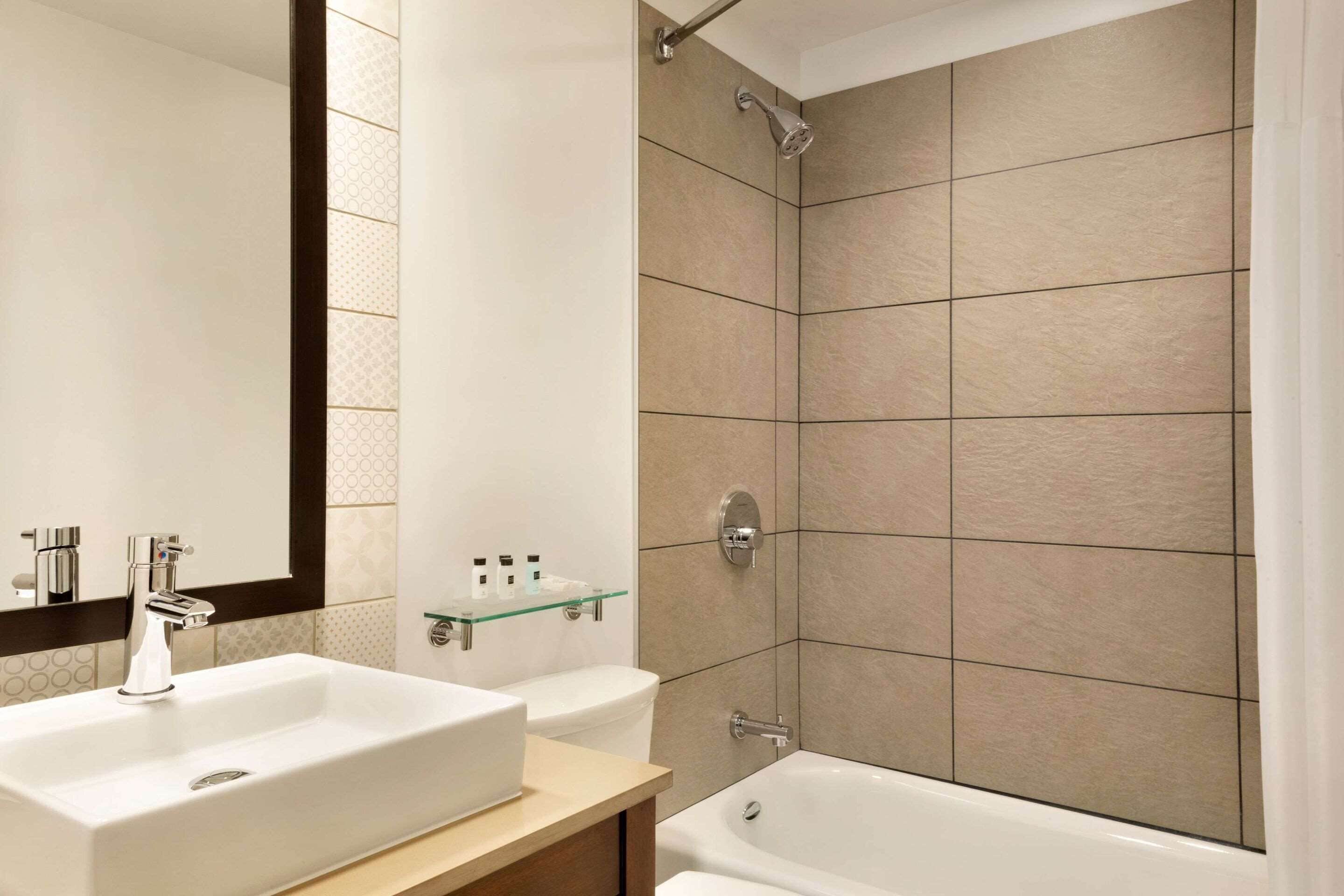 A modern bathroom with a large sink, toilet, and bathtub.