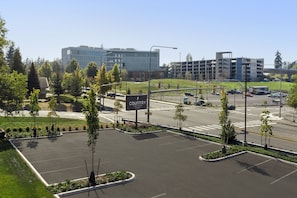 A parking lot with a Country Inn & Suites sign, surrounded by greenery and modern buildings.