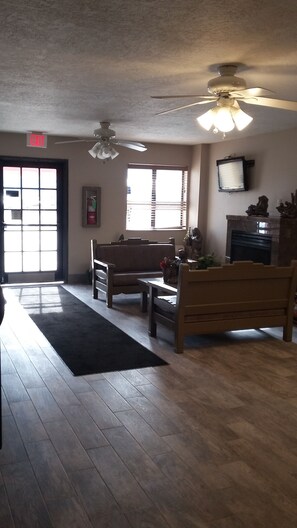 Relax in this cozy space with a fireplace, large window, and comfortable seating area.