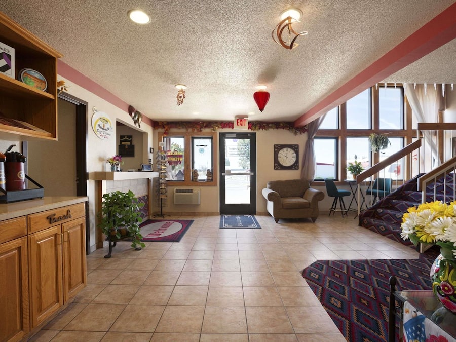 A spacious living area with a wooden cabinet, a couch, a staircase, and a large window providing natural light.