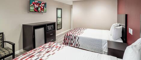 Une chambre d’hôtel avec deux lits, une télévision, un bureau, une chaise et un miroir.
