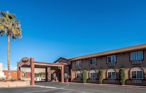 A Red Roof Inn with a covered parking area, palm trees, and a clear blue sky. - Red Roof Inn St George, UT - Convention Center (St. George)