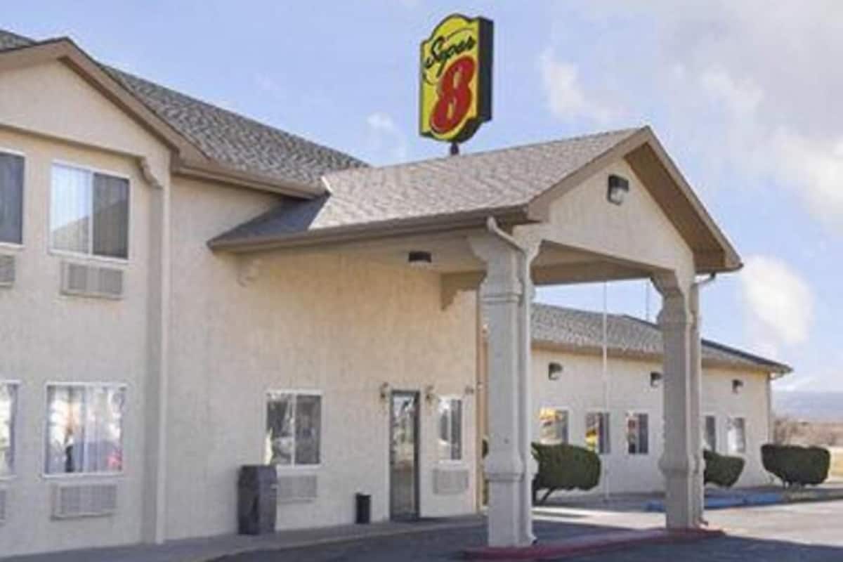 A motel with a covered entrance, a sign indicating it's number 8, and a parking lot.