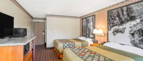 A hotel room with two beds, a TV, a desk, and a patterned floor.