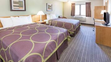 A hotel room with two beds, a desk, a chair, a TV, and an air conditioning unit.