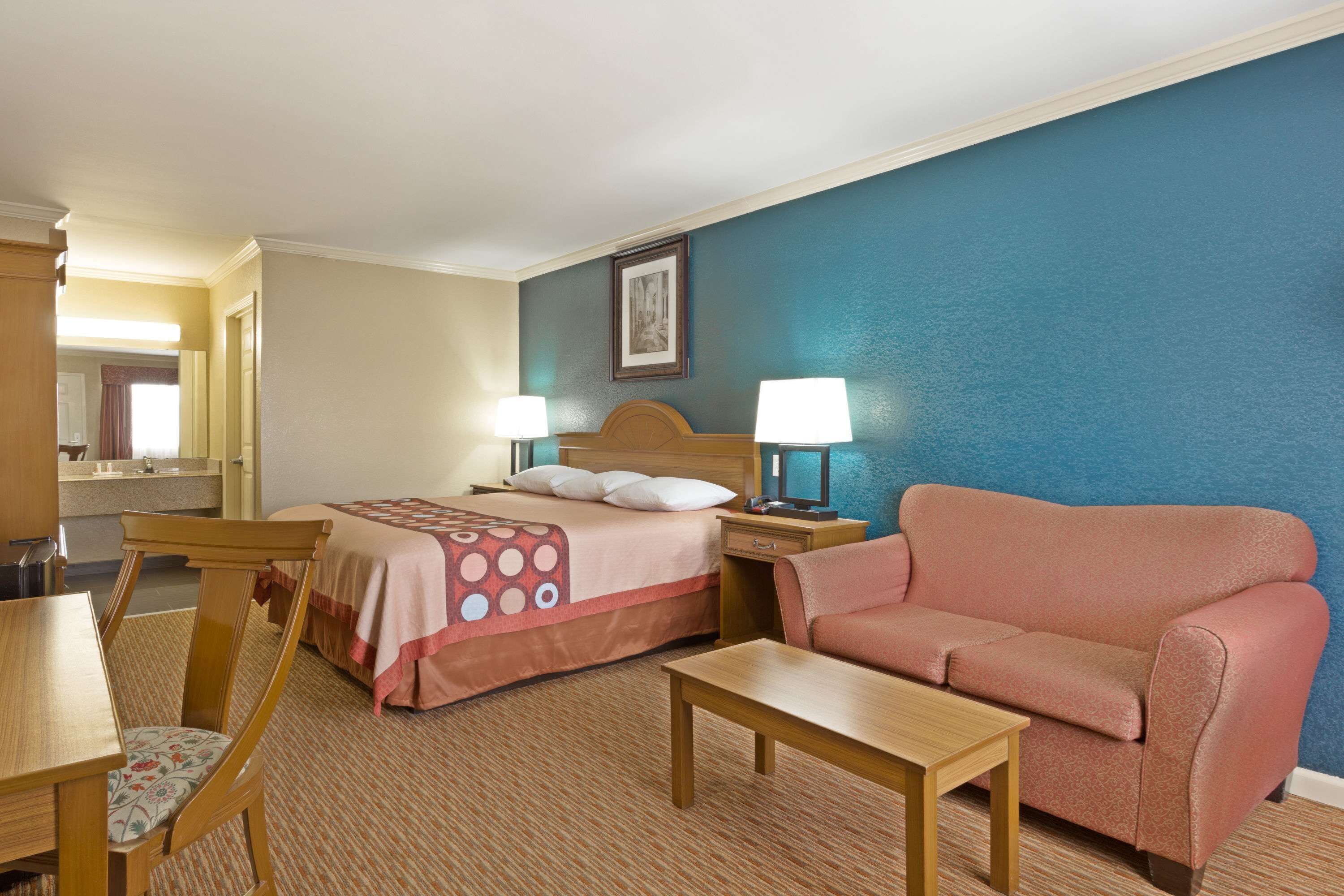 Een hotelkamer met een bed, een bank, een bureau en een stoel.