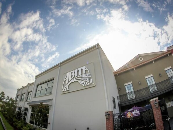 A building with a large 'ABITA' logo on the facade, featuring a stylized bird design. - Super 8 by Wyndham Covington (Covington)