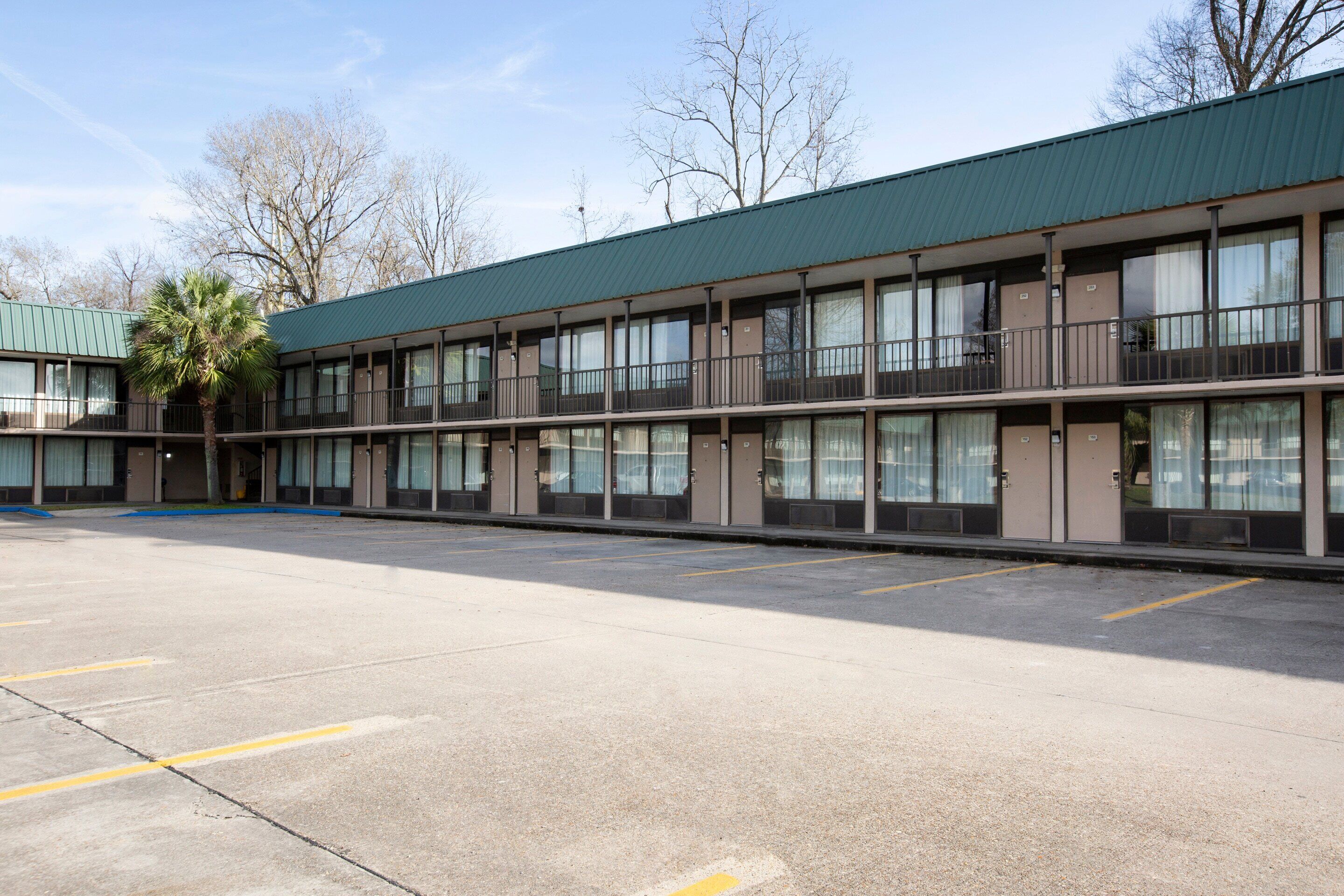 Un motel à plusieurs étages doté d’un toit végétalisé, de nombreux balcons et d’un parking.