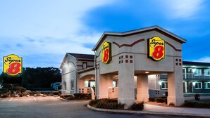 Et Super 8 hotel med et tydeligt skilt, en overdækket indgang og en parkeringsplads.