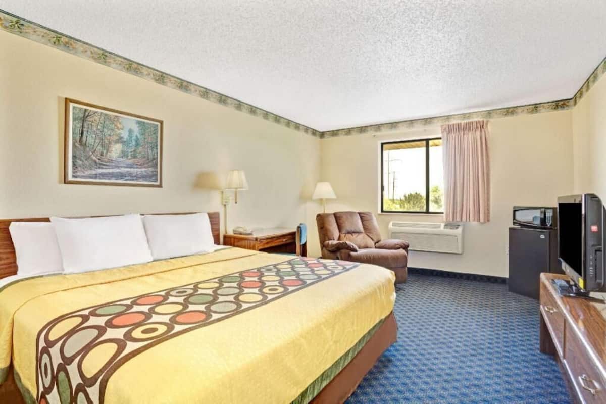 Escritorio, cortinas blackout y tabla de planchar con plancha