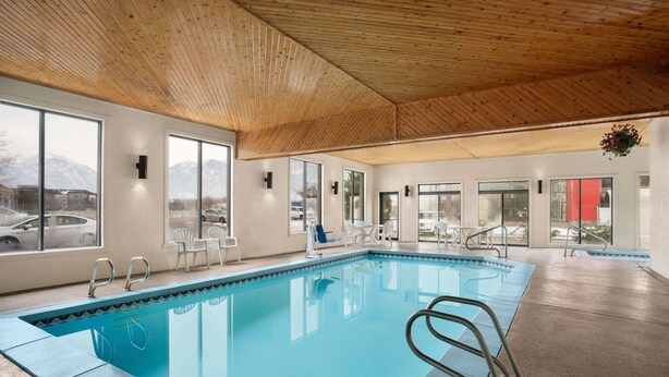 An indoor swimming pool with clear windows, white walls, and a wooden ceiling. - Super 8 by Wyndham S Jordan/Sandy/Slc Area (South Jordan)