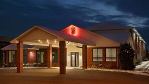 A hotel with a prominent 'Super 8' sign, a covered entrance, and a brick facade. - Super 8 by Wyndham S Jordan/Sandy/Slc Area (South Jordan)