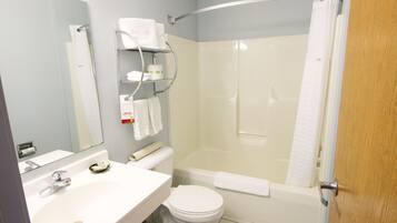 A bathroom with a sink, toilet, and shower area.