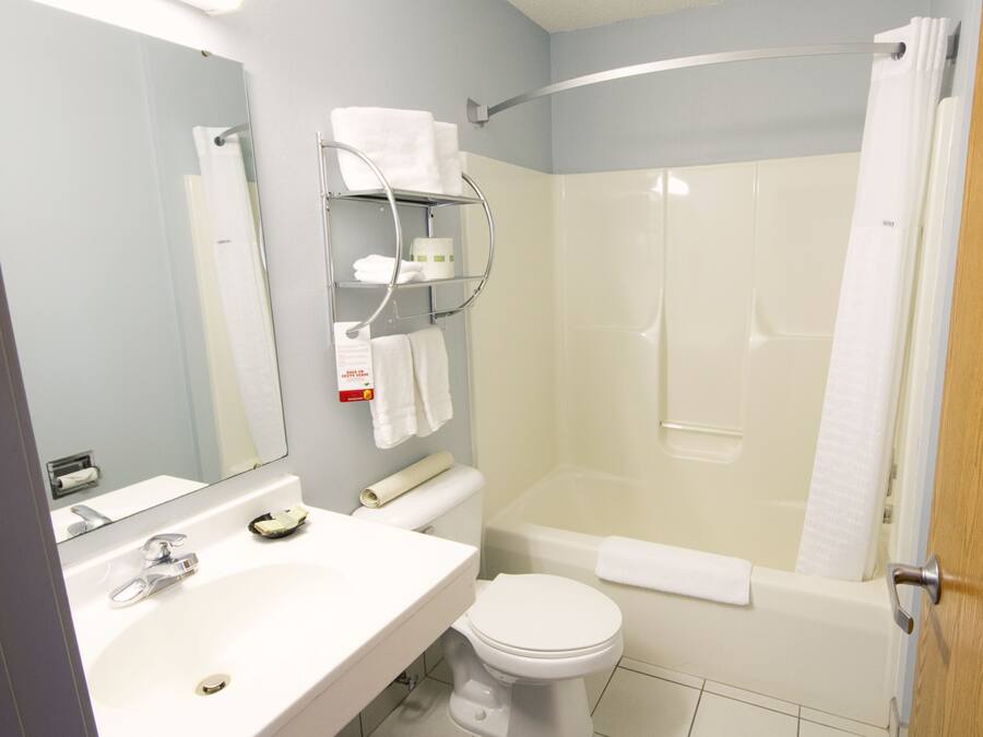 A bathroom with a sink, toilet, and shower area.