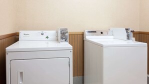 Dos lavadoras Whirlpool de carga frontal en un lavadero con paneles de madera y suelo de baldosas.