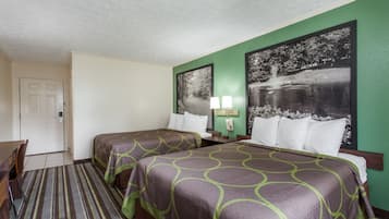 Habitación de hotel con dos camas, un escritorio y una silla.